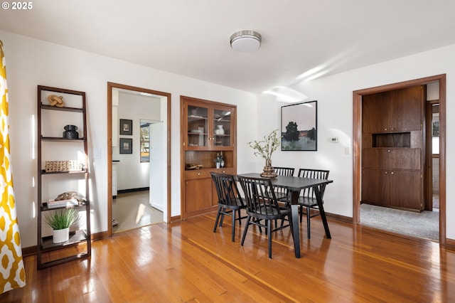 dining area featuring light wood-type flooring and baseboards