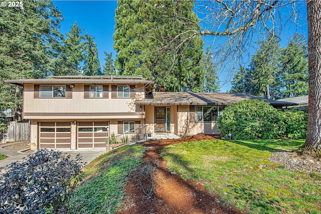 tri-level home with a garage, driveway, and a front lawn