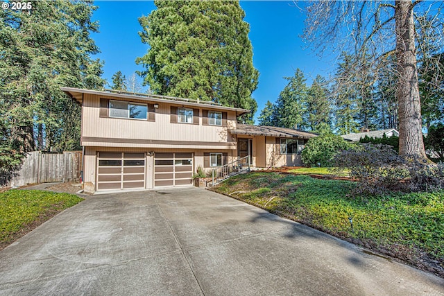 view of front of property with a garage, driveway, a front lawn, and fence