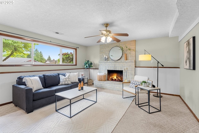 15648 NE Rose Pkwy, Portland, OR 97230 - carpeted living room featuring ceiling fan, a fireplace, a textured ceiling, and baseboards