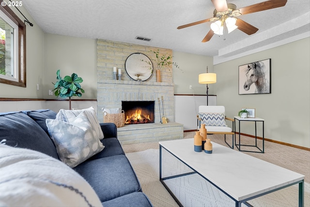 15648 NE Rose Pkwy, Portland, OR 97230 - carpeted living room featuring a fireplace, a ceiling fan, and a textured ceiling