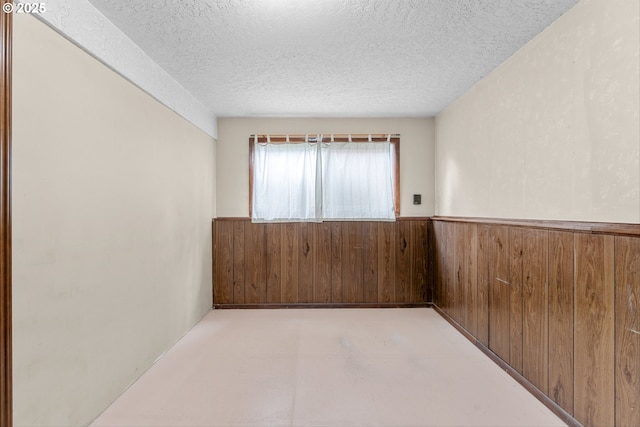 15648 NE Rose Pkwy, Portland, OR 97230 - spare room with wainscoting, wooden walls, and a textured ceiling