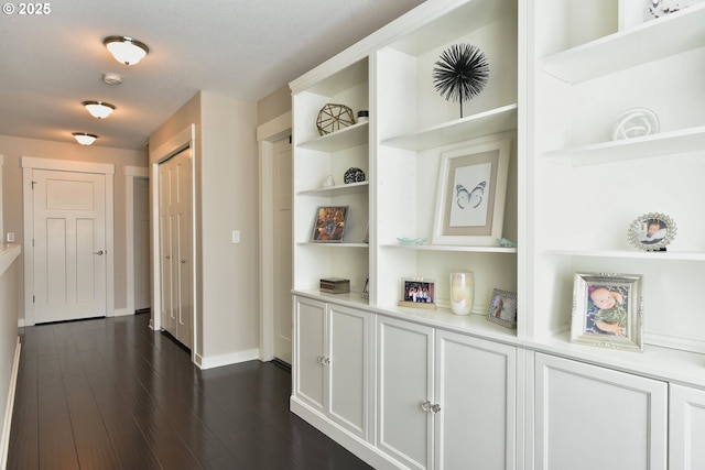 3225 SE Lincoln St, Portland, OR 97214 - corridor with baseboards, dark wood-type flooring, and built in shelves