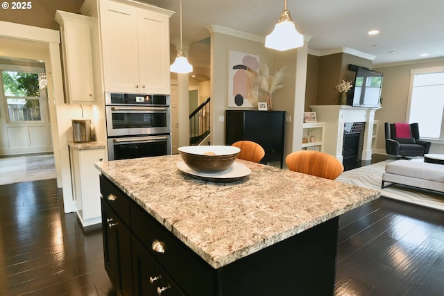 3225 SE Lincoln St, Portland, OR 97214 - kitchen featuring open floor plan, crown molding, a kitchen island, dark wood-style floors, and dark cabinetry