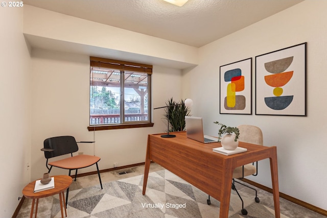 office space featuring a textured ceiling, visible vents, and baseboards