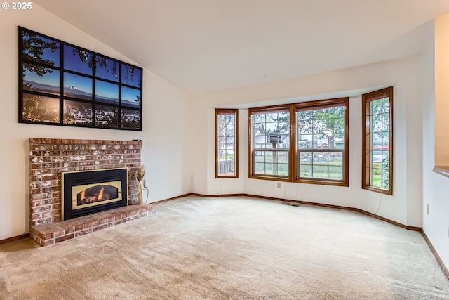 unfurnished living room with lofted ceiling, carpet, plenty of natural light, and a fireplace