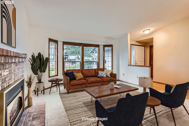 living area featuring a fireplace and baseboards