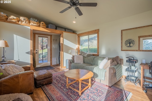 living room featuring lofted ceiling, ceiling fan, and light hardwood / wood-style flooring