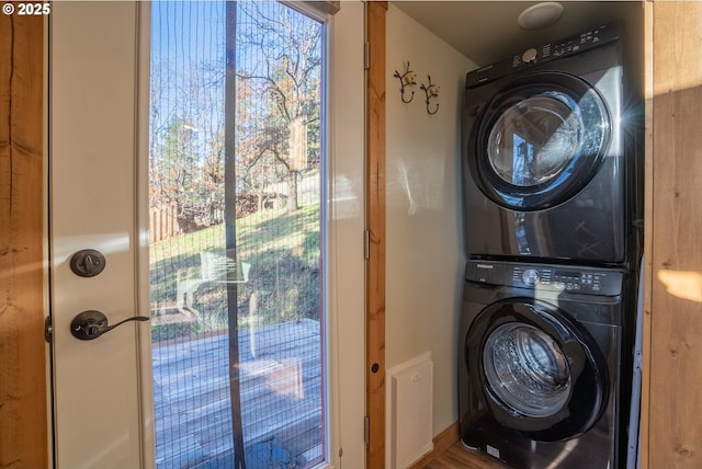 clothes washing area featuring stacked washer / dryer