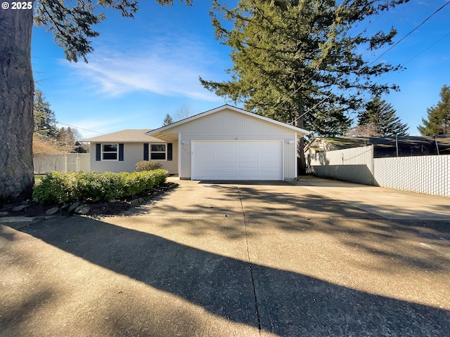 ranch-style home featuring an attached garage, concrete driveway, and fence