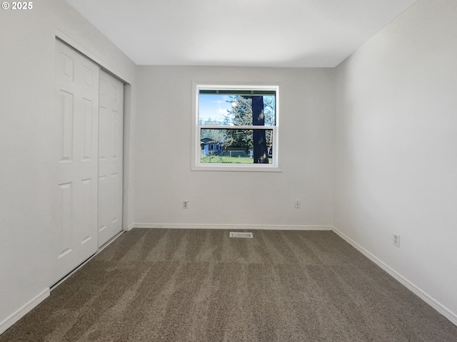 unfurnished bedroom featuring carpet, a closet, and baseboards