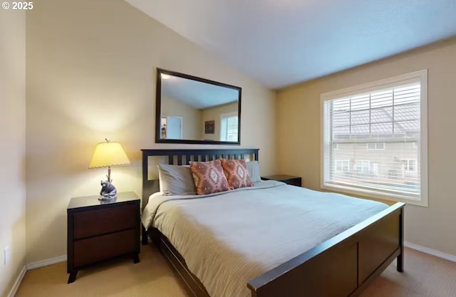 bedroom with baseboards, light colored carpet, and lofted ceiling
