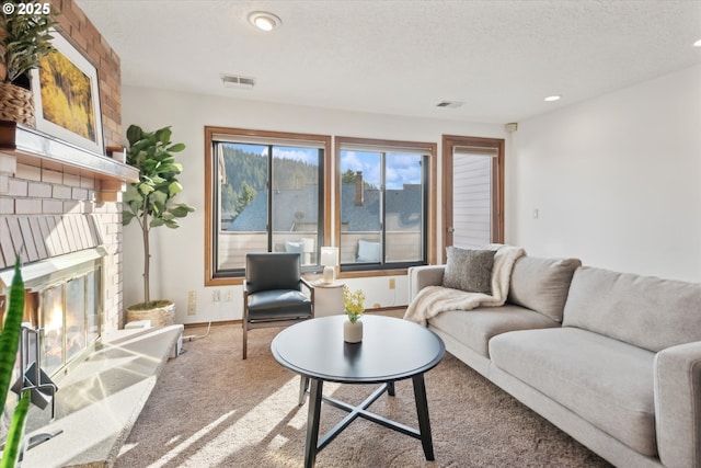 carpeted living room with a textured ceiling and a fireplace