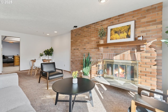 living room featuring a textured ceiling, a fireplace, and light carpet