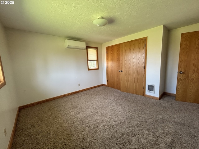 11623 Broadacres Rd NE, Hubbard, OR 97032 - unfurnished bedroom with a textured ceiling, carpet floors, baseboards, a closet, and an AC wall unit