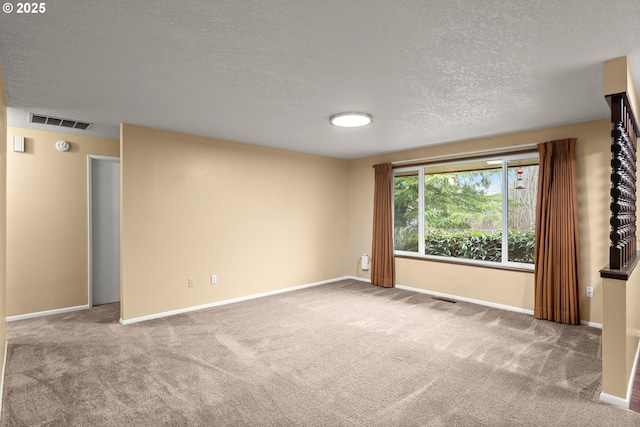 carpeted empty room with a textured ceiling