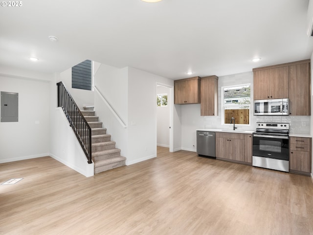 kitchen with electric panel, stainless steel appliances, a wealth of natural light, and sink