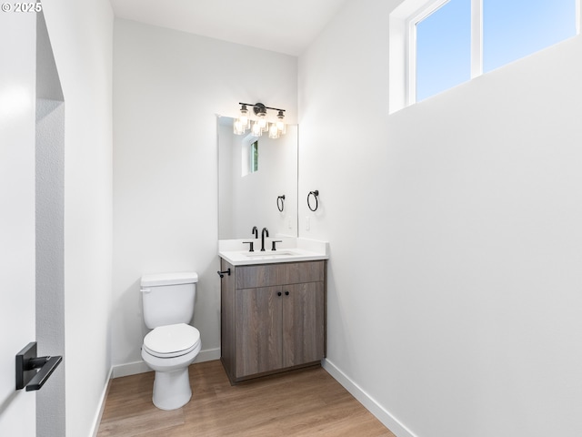 bathroom with hardwood / wood-style flooring, vanity, and toilet