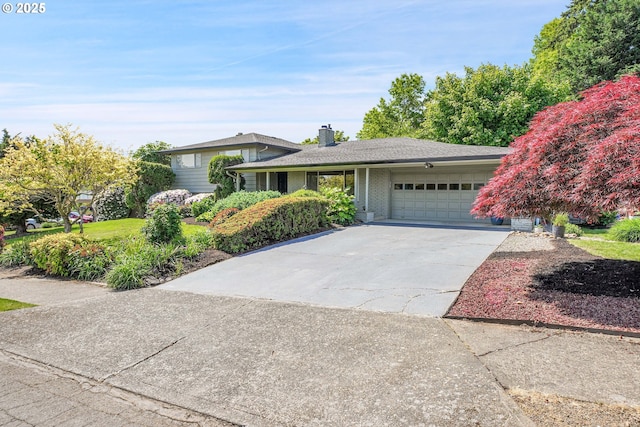 4729 SE Concord Rd, Milwaukie, OR 97267 - split level home with a garage, concrete driveway, a chimney, and brick siding