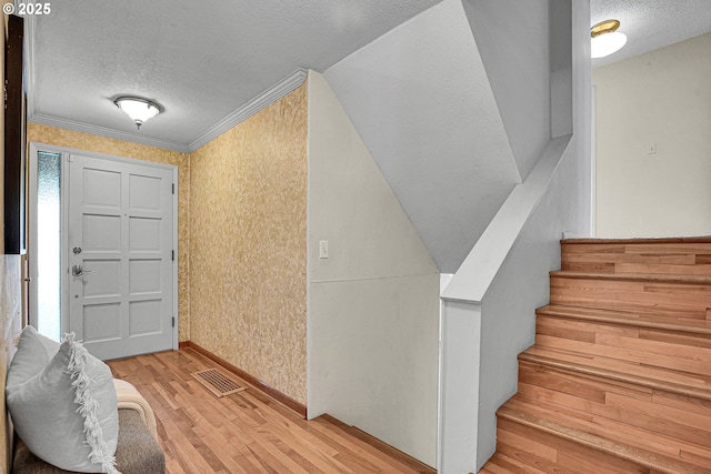 4729 SE Concord Rd, Milwaukie, OR 97267 - entrance foyer featuring a textured ceiling, light wood-style floors, stairway, baseboards, and ornamental molding
