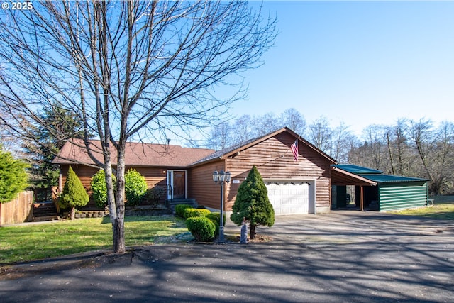 ranch-style home with an attached garage, fence, driveway, a carport, and a front yard