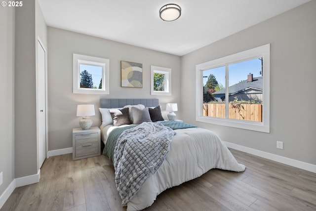 bedroom featuring baseboards and light wood-style flooring