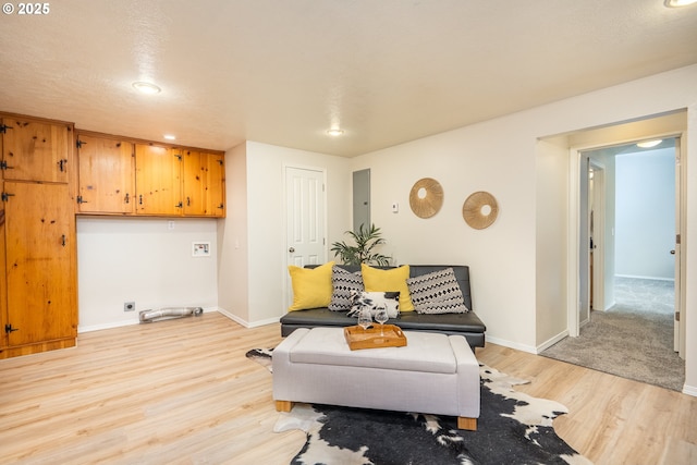 living area featuring light wood finished floors, baseboards, and recessed lighting