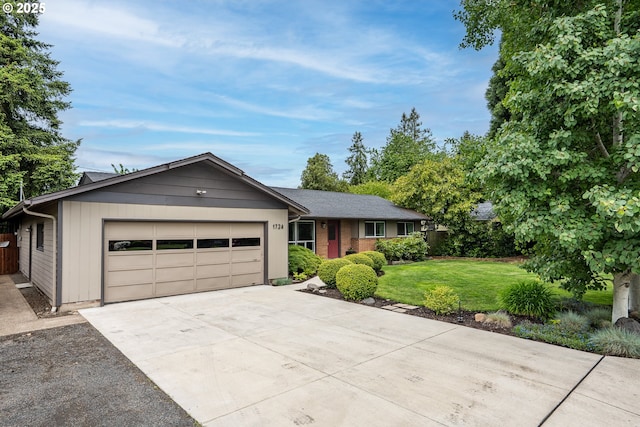 ranch-style house featuring a garage, a front yard, and driveway