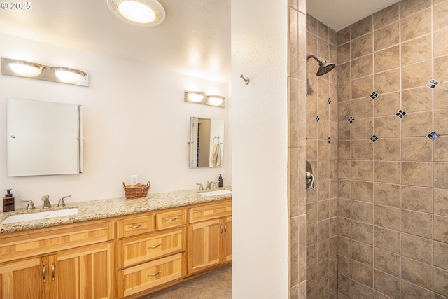 bathroom featuring double vanity, tiled shower, and tile patterned floors