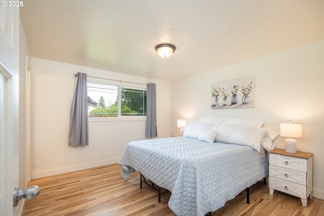 bedroom with light wood-type flooring and baseboards