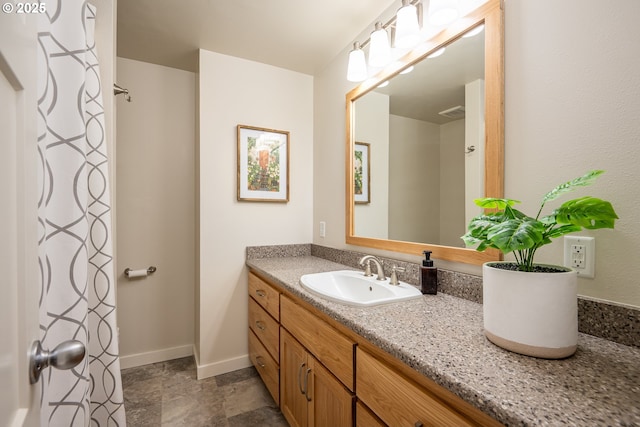 bathroom featuring vanity, baseboards, a shower with curtain, and stone finish flooring