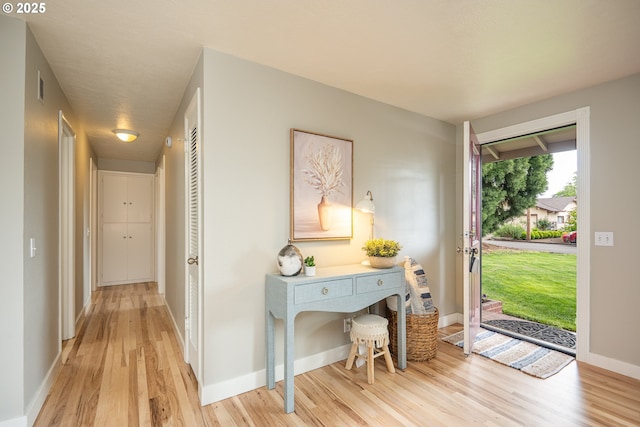 foyer with light wood-style flooring and baseboards