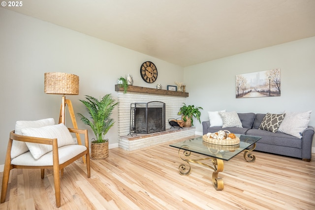 living room featuring wood finished floors, a fireplace, and baseboards