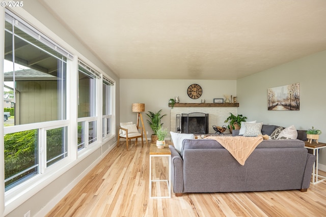 living room featuring wood finished floors, a fireplace, and baseboards