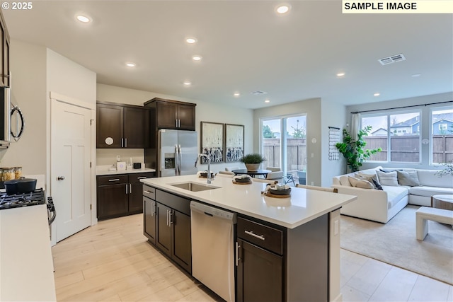 23870 SW Vermillion Dr, Tualatin, OR 97062 - kitchen with stainless steel appliances, a sink, light countertops, dark brown cabinets, and open floor plan