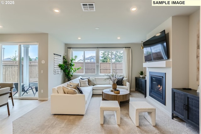 23870 SW Vermillion Dr, Tualatin, OR 97062 - living room featuring baseboards, a glass covered fireplace, recessed lighting, and light wood-style flooring