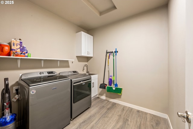 7220 SE Night Hawk Ct, Prineville, OR 97754 - clothes washing area featuring cabinet space, baseboards, light wood-type flooring, washing machine and dryer, and a sink
