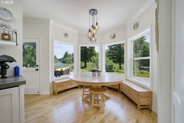 dining area with light hardwood / wood-style floors, breakfast area, and crown molding