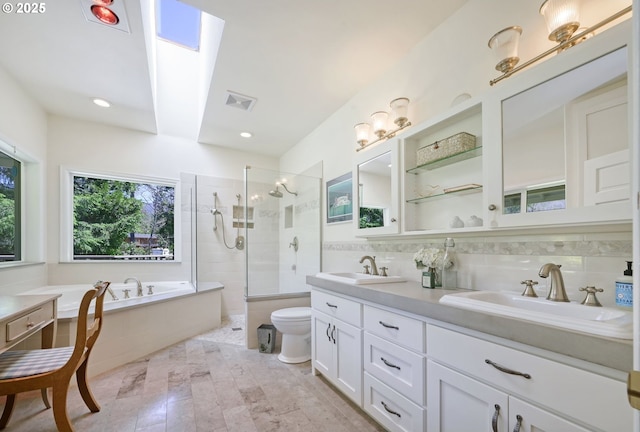 bathroom featuring tile walls, vanity, a skylight, and separate shower and tub