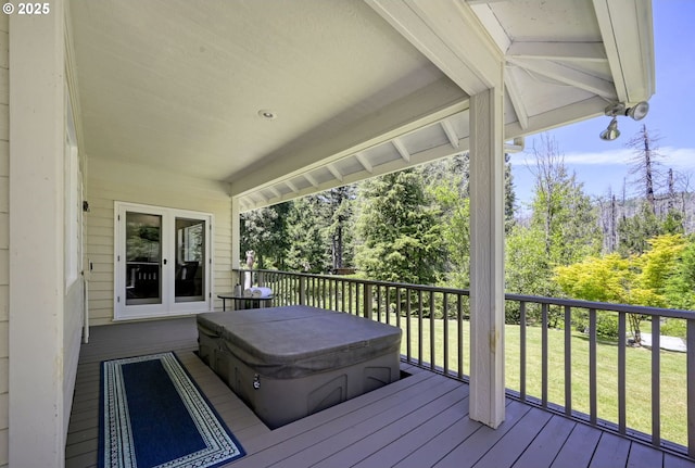 deck with a lawn and a covered hot tub