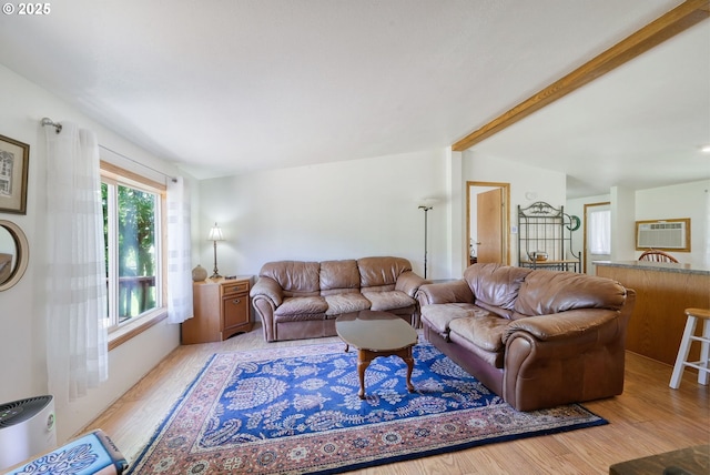 living room with light wood-type flooring, beam ceiling, and an AC wall unit