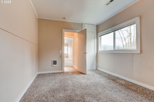 unfurnished bedroom featuring crown molding, carpet flooring, and heating unit