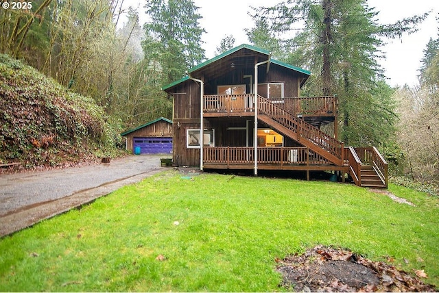 exterior space with a garage, a deck, an outbuilding, and a front yard