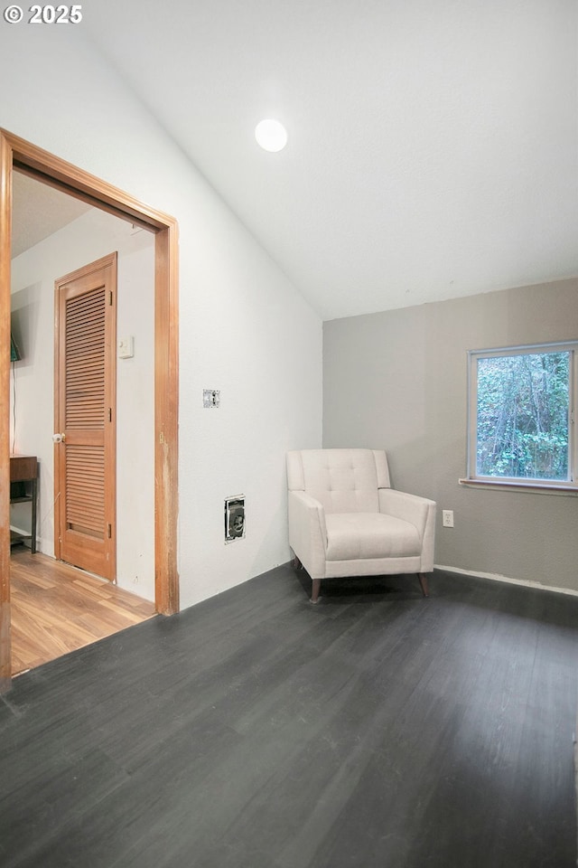 unfurnished room with hardwood / wood-style floors, lofted ceiling, and heating unit