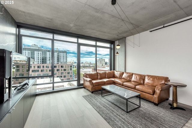 1410 NW Kearney St Unit 721, Portland, OR 97209 - living area featuring a city view, expansive windows, wood finished floors, and a healthy amount of sunlight