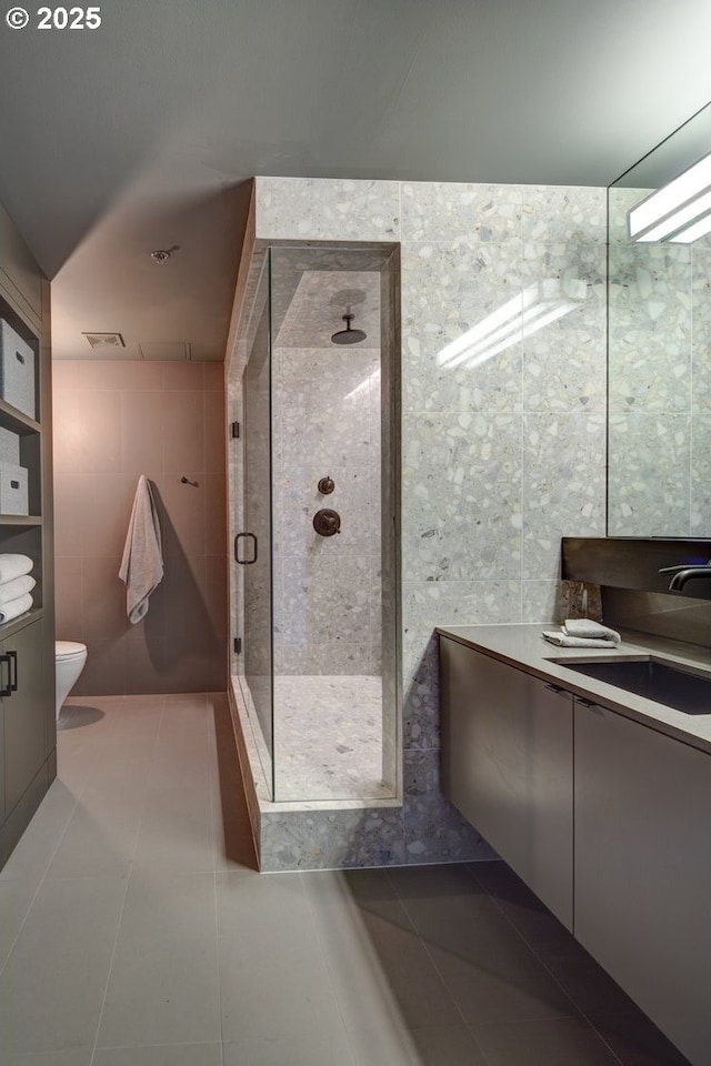 1410 NW Kearney St Unit 721, Portland, OR 97209 - full bath with tile patterned floors, toilet, tile walls, a shower stall, and vanity