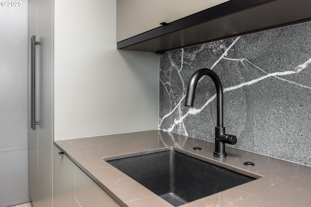 1410 NW Kearney St Unit 721, Portland, OR 97209 - room details with under cabinet range hood, white cabinetry, decorative backsplash, and a sink
