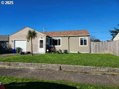 ranch-style home with a garage and a front lawn