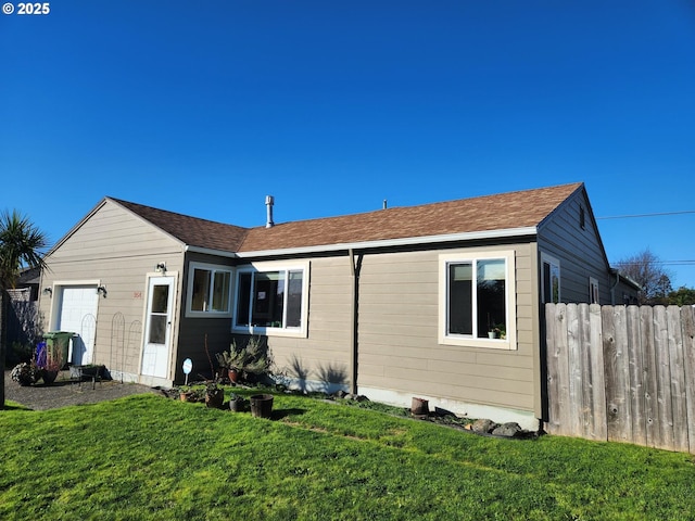 view of front of house featuring a garage, fence, and a front yard