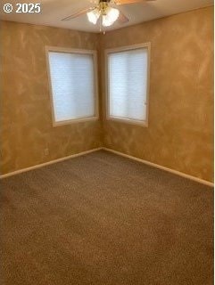 spare room featuring a ceiling fan, carpet, and baseboards